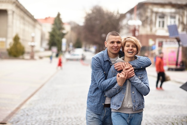 Junges Paar, das die Straße einer gemütlichen Stadt entlang geht