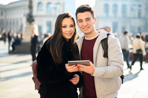 Junges Paar, das eine digitale Tablette im Freien beim Besuch einer Stadt verwendet