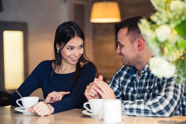 Junges Paar, das im Café spricht