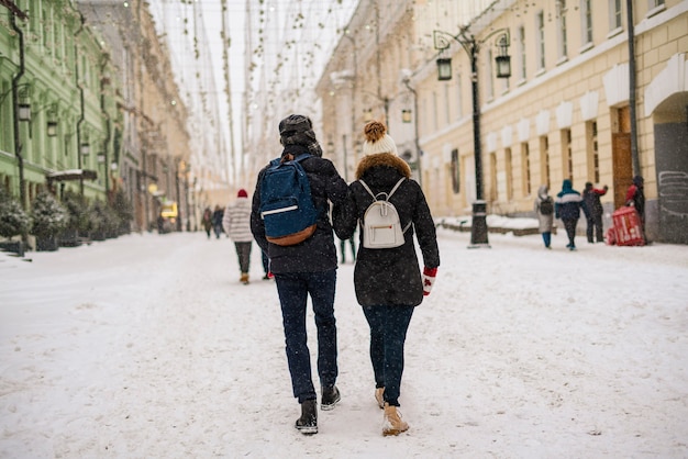 Junges Paar, das in der Wintersaison einen Spaziergang in den Straßen der Stadt genießt