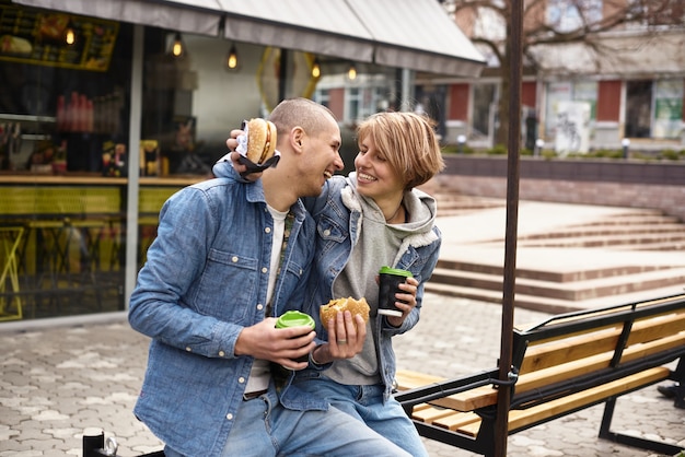 Junges Paar, das Kaffee beim Gehen durch die Stadt trinkt