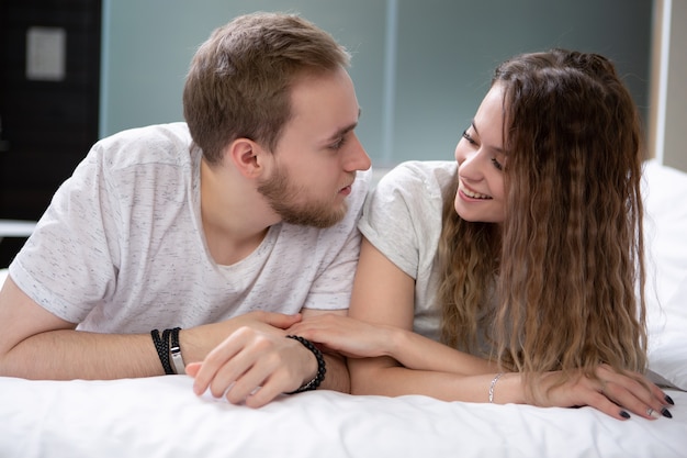 Junges Paar, das oben im Bett sitzt