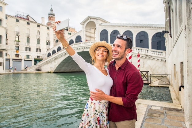 junges Paar, das Spaß hat, während es Venedig besucht - Touristen, die in Italien reisen und die wichtigsten Sehenswürdigkeiten von Venezia besichtigen - Konzepte über Lebensstil, Reisen, Tourismus