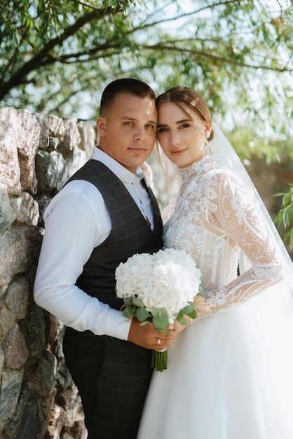 Junges Paar der Bräutigam in einem karierten Anzug und die Braut in einem schicken weißen Kleid