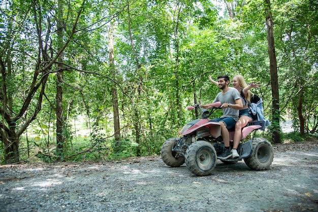 Junges Paar fährt ATV durch den Wald mit Freude und AufregungAbenteuerreisen