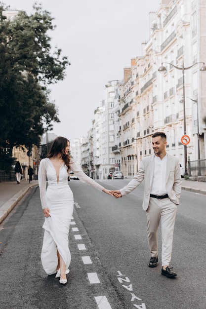 Junges Paar geht durch die Straßen von Frankreich Frau in einem weißen Kleid und Mann in einem Anzug