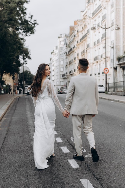 Junges Paar geht durch die Straßen von Frankreich Frau in einem weißen Kleid und Mann in einem Anzug