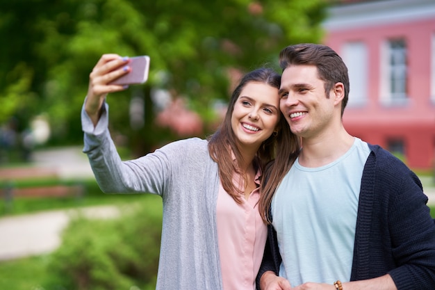 junges Paar im Park spazieren und fotografieren