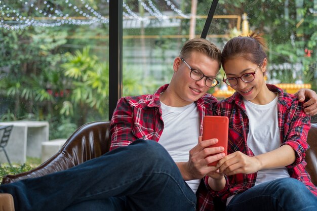 Junges Paar in der Liebe, die an einem Café sitzt, nimmt ein selfie Porträt mit Kameratelefon