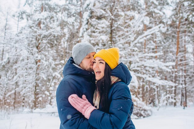 Junges Paar in der Liebe geht in den Winterwald, aktive Winterferien