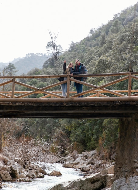 Foto junges paar in der natur, die auf brücke sitzt