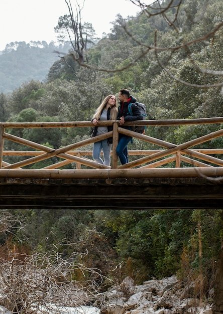 Foto junges paar in der natur, die auf brücke sitzt