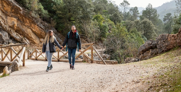 Foto junges paar in der natur, die auf brücke sitzt