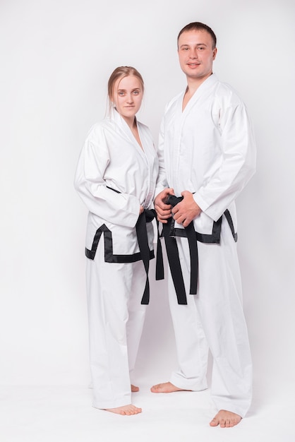 junges Paar in Taekwondo-Uniform auf Weiß