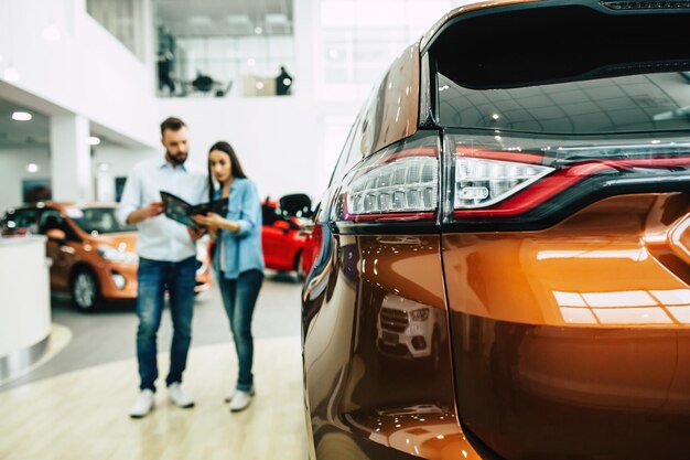 Junges Paar kauft ein neues Auto im Autohaus