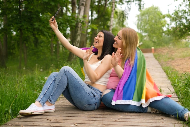 Junges Paar kaukasischer Frauen mit LGBT-Flagge