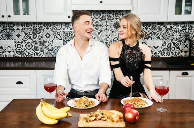 Junges Paar lacht beim Essen von Spaghetti