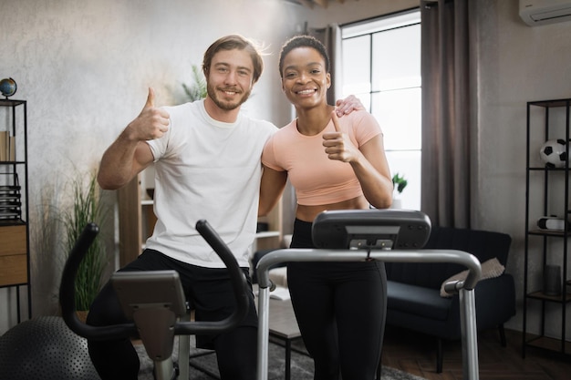 Junges Paar macht Cardio auf stationärem Fahrrad und Laufband