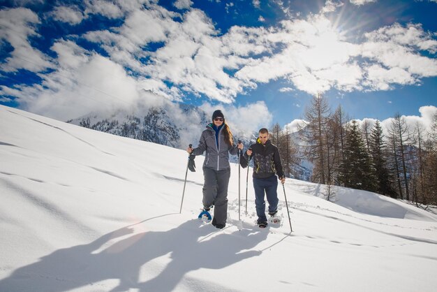 Junges Paar macht Schneeschuhwanderungen in den Bergen