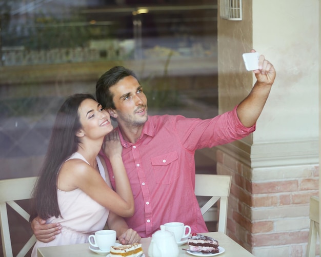 Junges Paar macht Selfie im Café