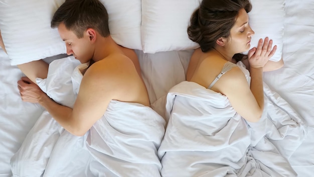Junges Paar Mann und Frau schlafen nach Streit wegdrehen