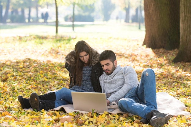 Junges Paar mit Laptop im Freien im Park