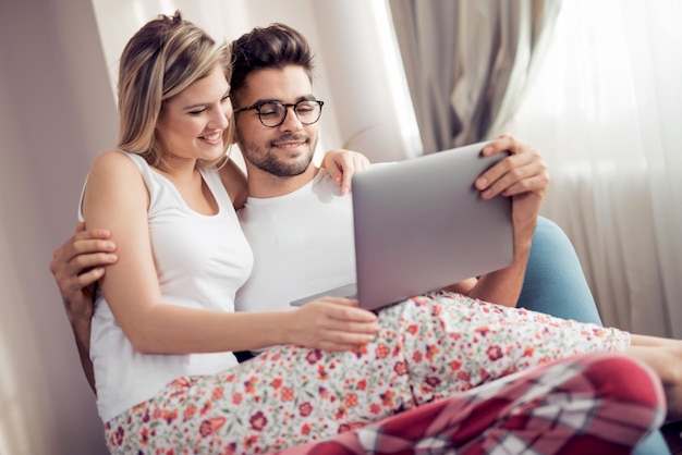 Junges Paar mit Laptop im Wohnzimmer