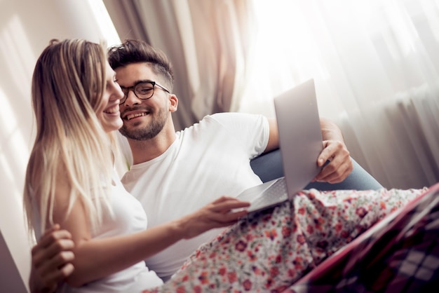 Junges Paar mit Laptop im Wohnzimmer