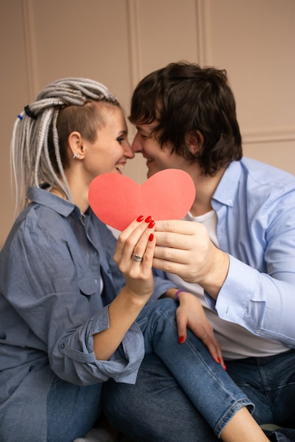 Junges Paar mit rotem Herz Valentinstag in Händen.