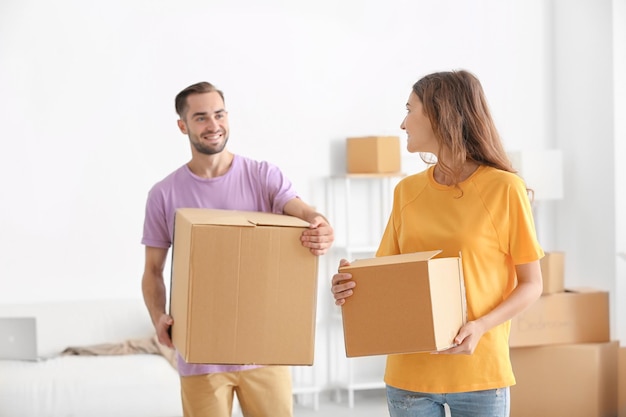 Junges Paar mit Umzugskartons im neuen Zuhause