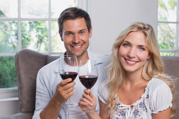 Junges Paar mit Weingläsern zu Hause