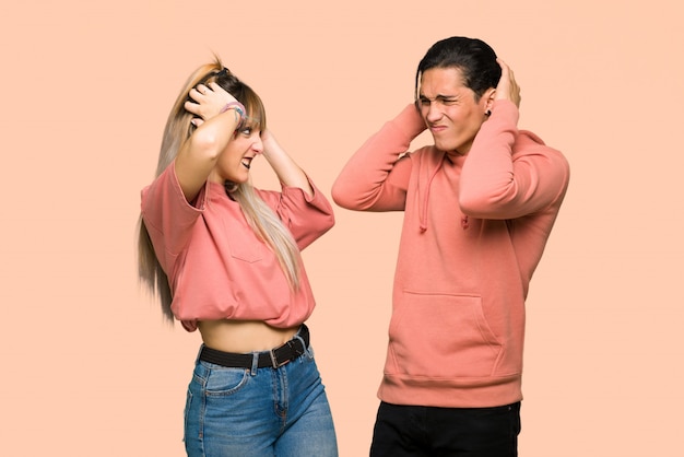 Junges Paar nimmt Hände am Kopf, weil Migräne hat