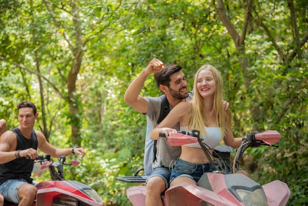 Junges Paar oder Freund glücklich beim Reiten eines ATV im Wald