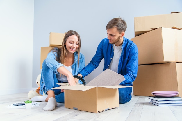 Junges Paar packt Dinge aus, nachdem es in neues Haus gezogen ist