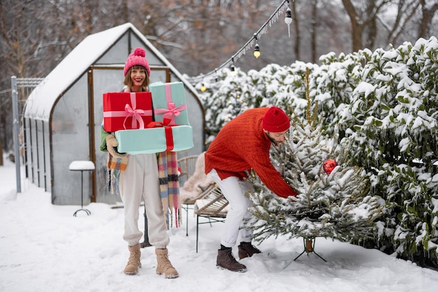 Foto junges paar schmückt weihnachtsbaum im hinterhof