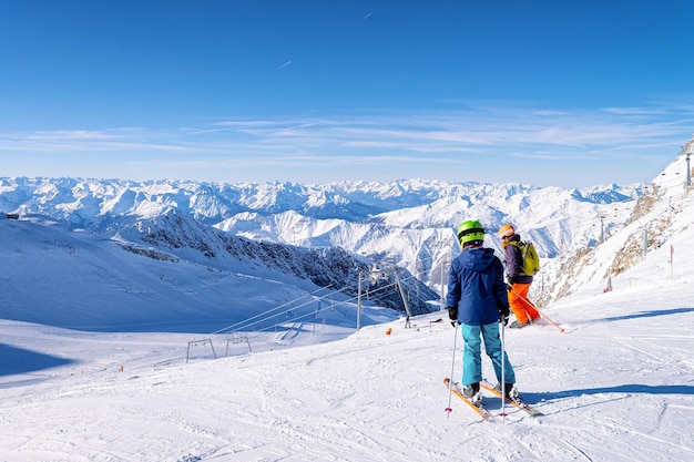 Junges Paar Skifahrer beim Skifahren am Hintertuxer Gletscher in Tirol in Mayrhofen in Österreich, Winteralpen. Menschen Skifahren am Hintertuxer Gletscher in den Alpenbergen mit weißem Schnee und blauem Himmel