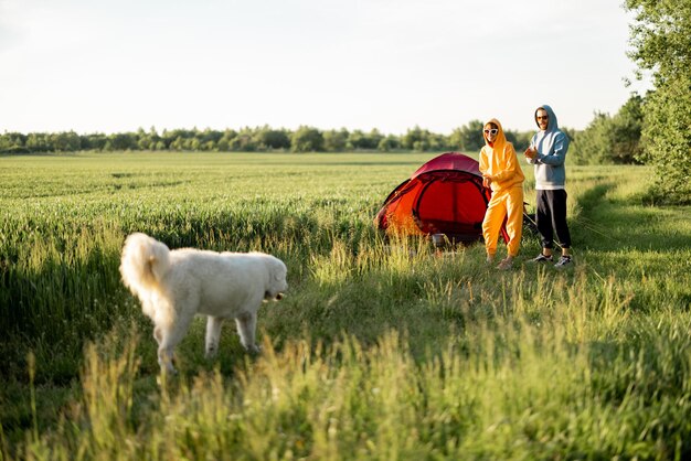 Junges Paar spielt mit seinem Hund auf dem Campingplatz