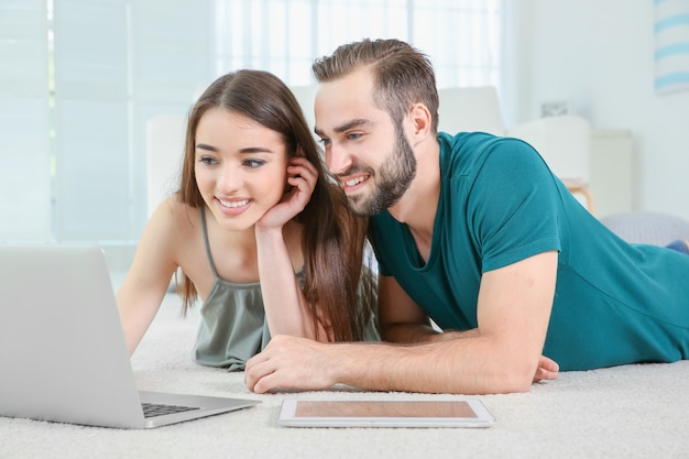 Junges Paar sucht zu Hause nach Informationen mit Laptop laptop