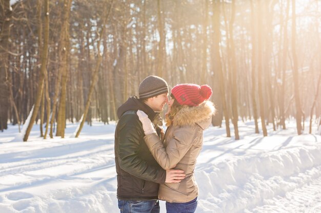 Junges Paar umarmt und küsst sich im Winter im Park.