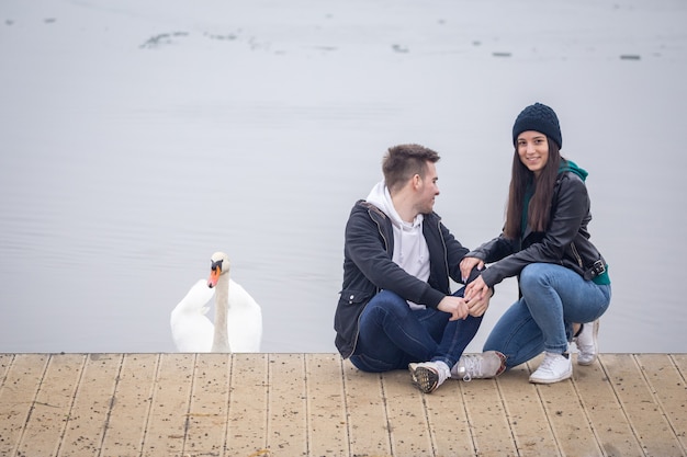 Foto junges paar verbringt zeit zusammen und ein schwan gesellt sich an einem nebligen wintertag