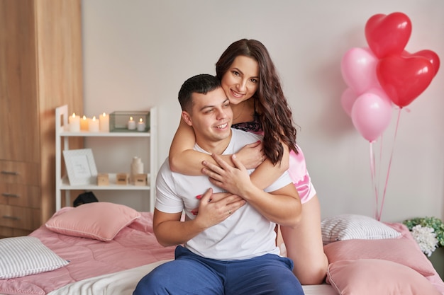 Junges Paar verliebt in zu Hause auf Bett, das Valentinstag feiert