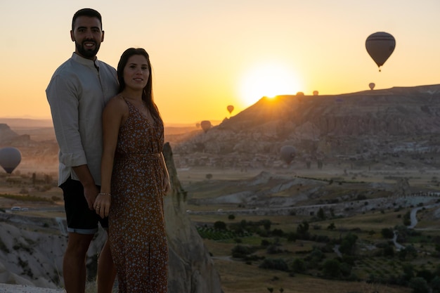 Junges Paar verliebte Touristen bei Sonnenaufgang in Kappadokien mit Luftballons am Himmel