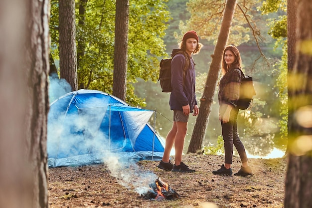 Junges Paar Wanderer, die im Lager im Wald stehen. Reise-, Tourismus- und Wanderkonzept.