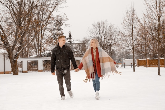 Junges romantisches Paar hat Spaß im Freien im Winter. Zwei Liebende umarmen und küssen sich am Valentinstag.