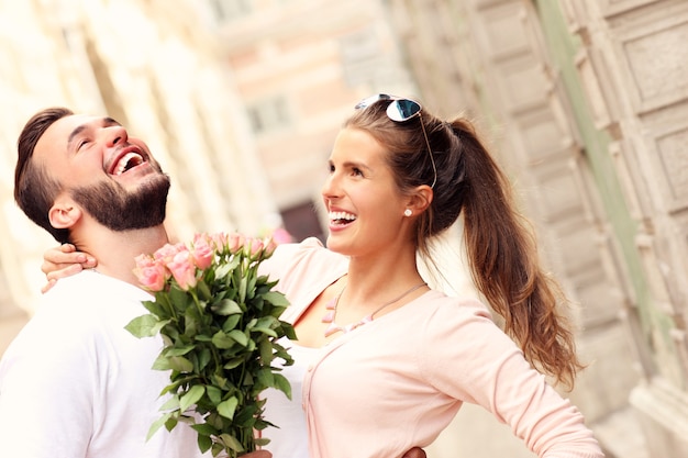 junges romantisches Paar mit Blumen in der Stadt