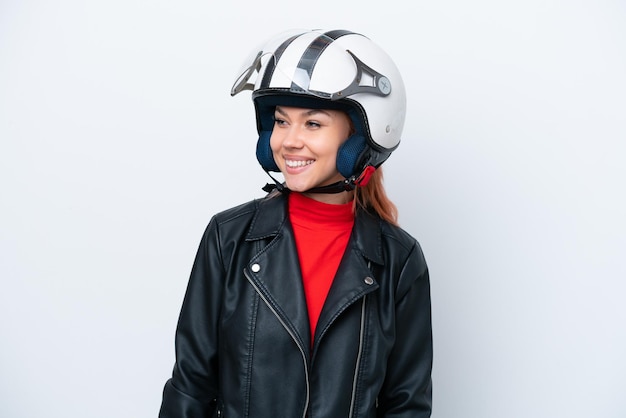 Junges russisches Mädchen mit einem Motorradhelm, der auf der Seite des weißen Hintergrunds lokalisiert wird