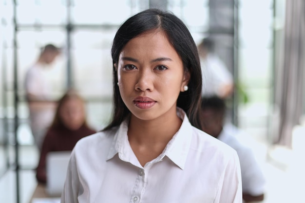 Junges schönes asiatisches Geschäftsfrau-Beraterporträt eines Angestellten, der die Kamera betrachtet