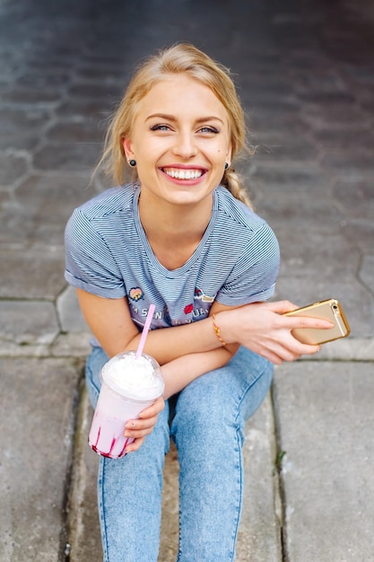 Foto junges schönes blondes mädchen, das durch die straßen der stadt geht