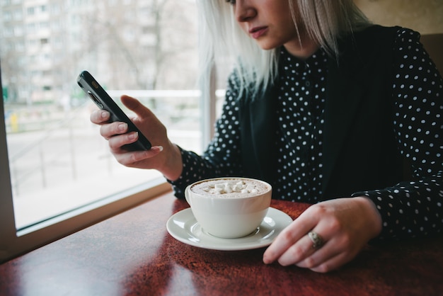 Junges schönes blondes Mädchen in einem Café