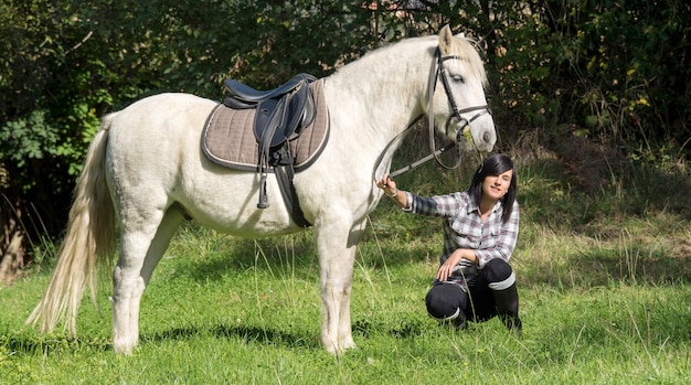 Junges schönes Brunettefrauen-Reitpferd